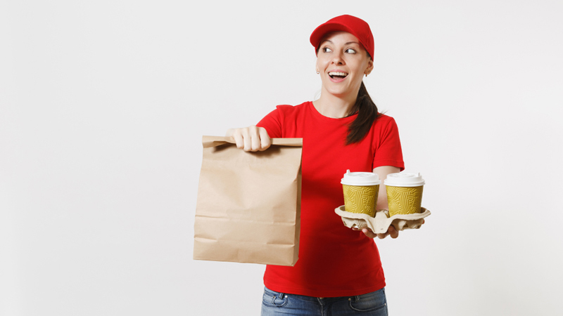 A girl in a red shirt holding a delivery bag